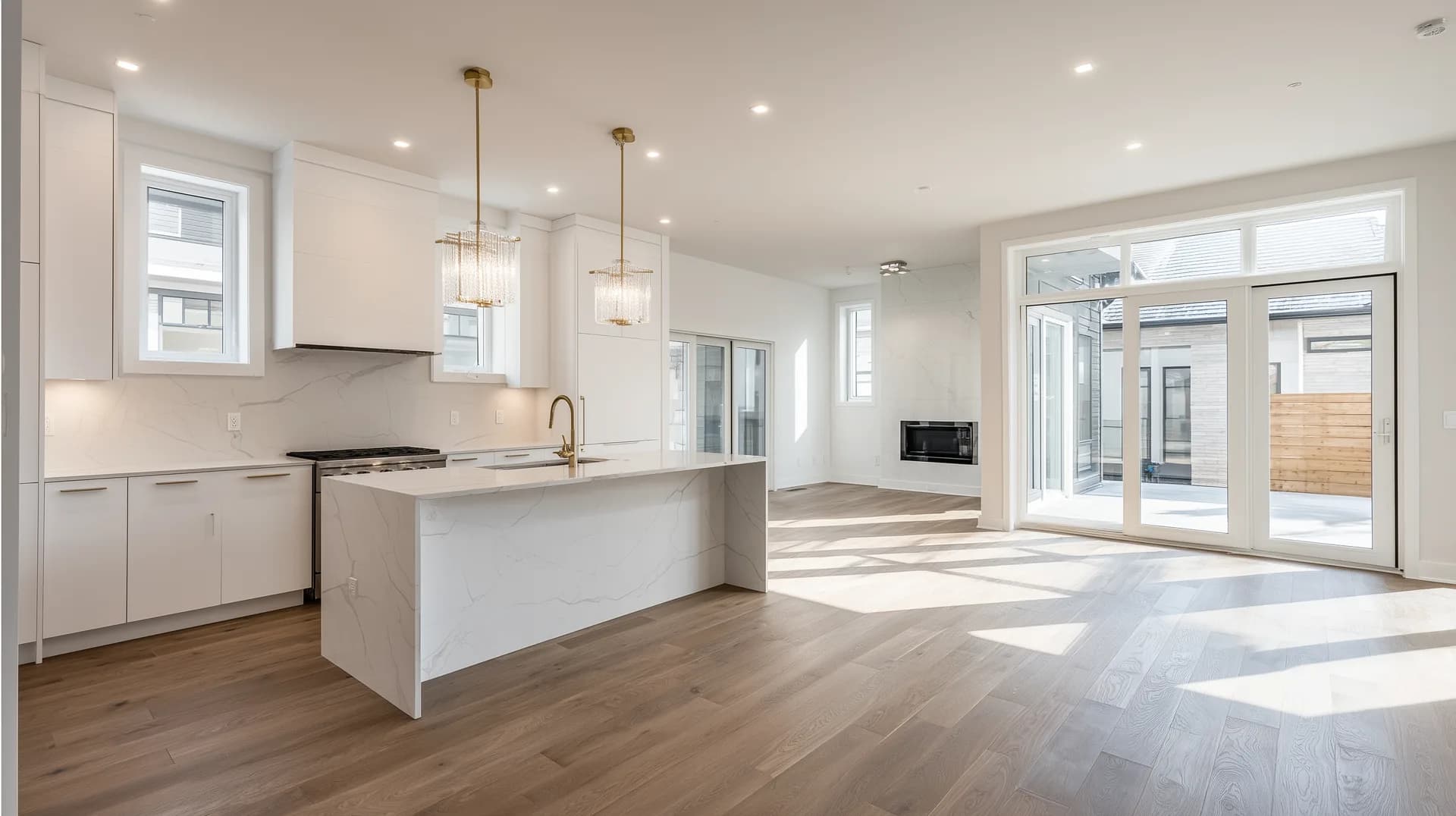 Pristine new construction open-concept kitchen and living area with white cabinetry and hardwood floors