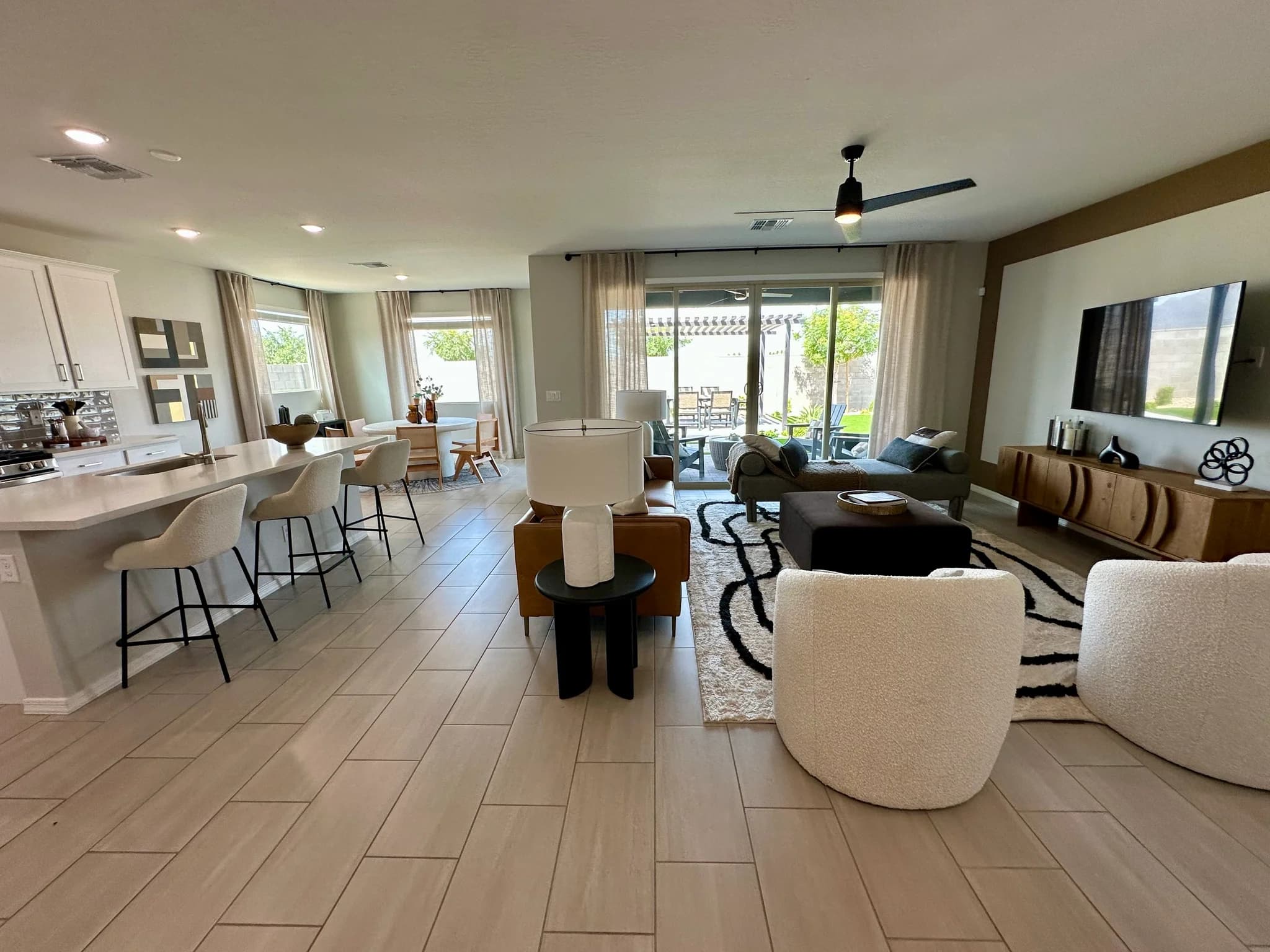 Model home great room with white sofas and an open dining area