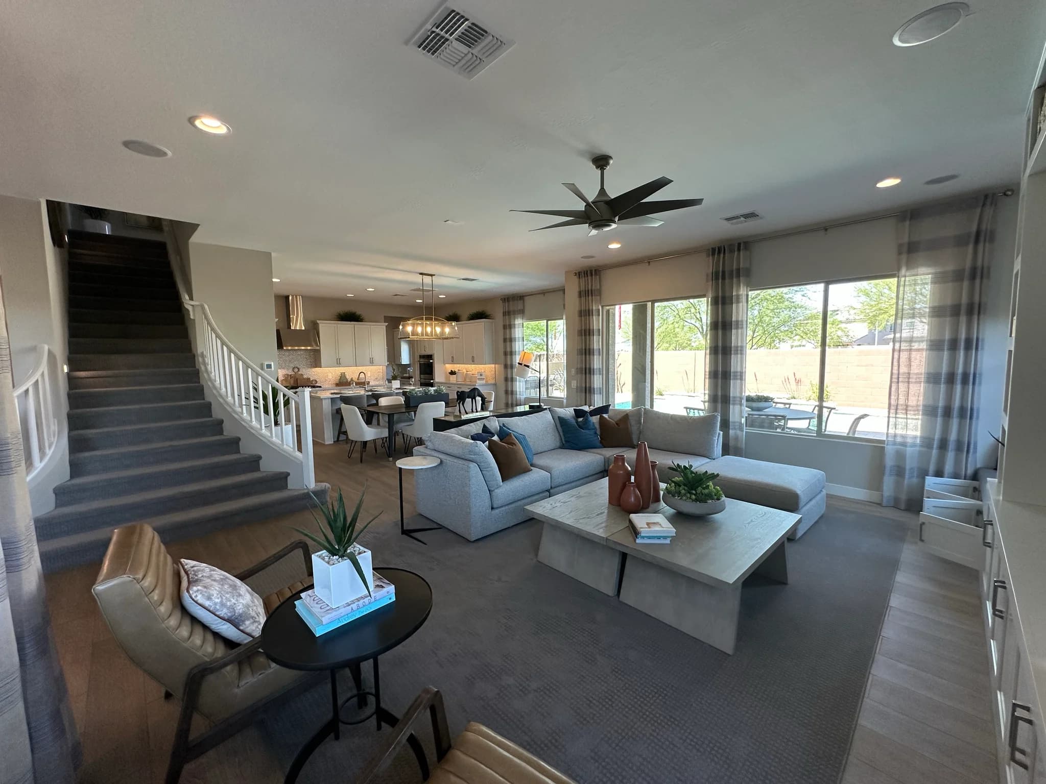 Model home great room with a staircase and open kitchen