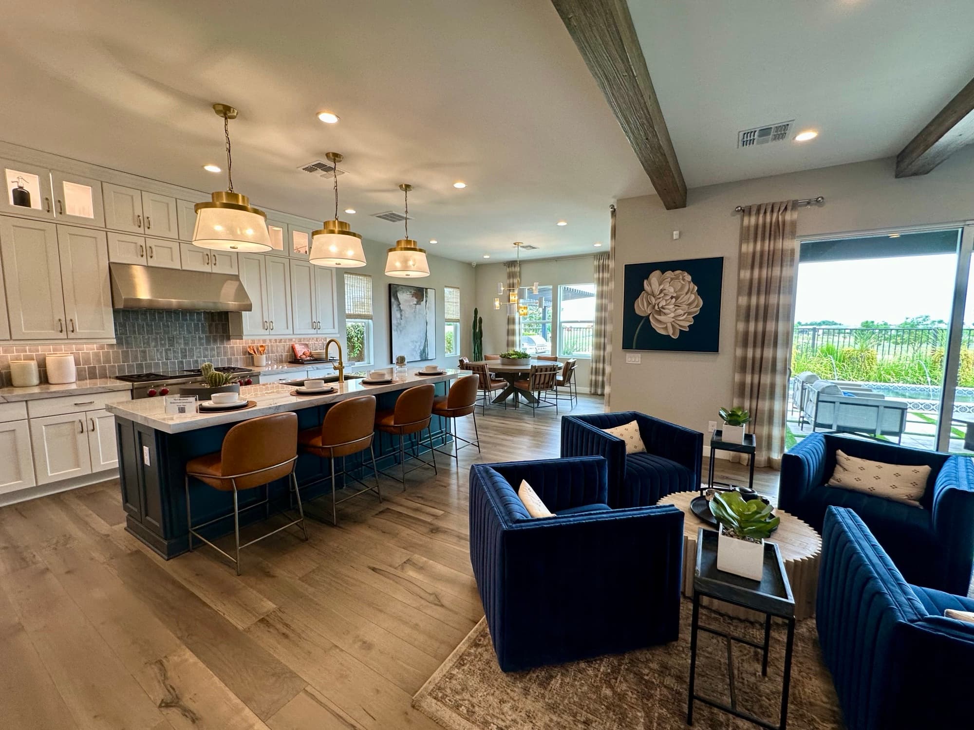 Model home great room with a kitchen island and wall of windows
