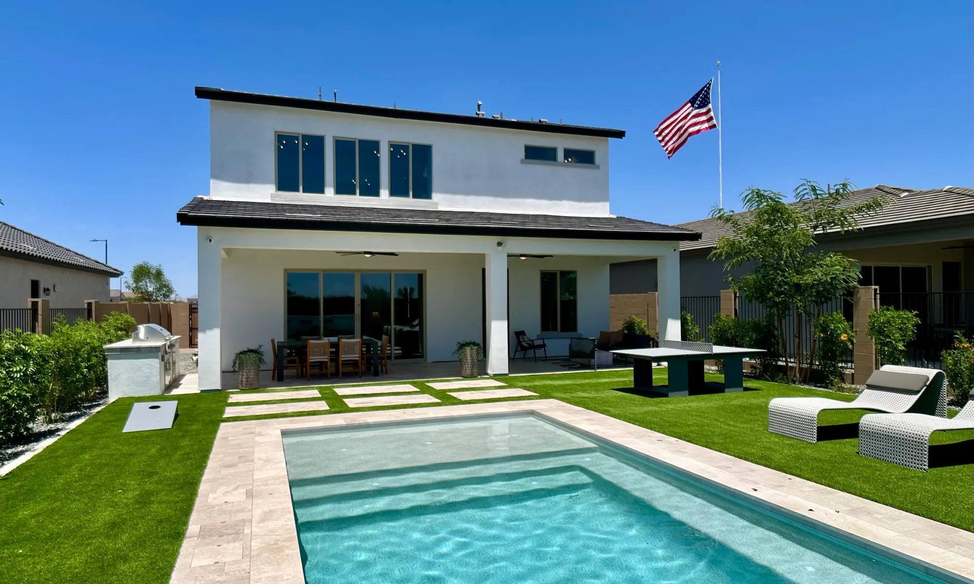 Phoenix new-build backyard with a pool, turf, and outdoor kitchen
